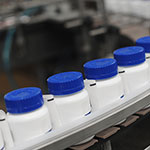 Blue-Capped-Drug-Bottles-on-Conveyor